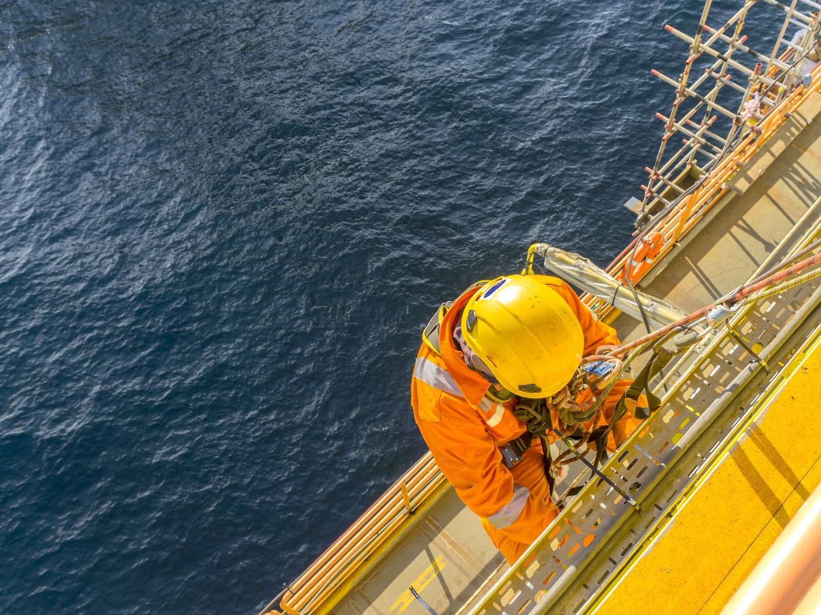 Operations technician working at height on a marine platform